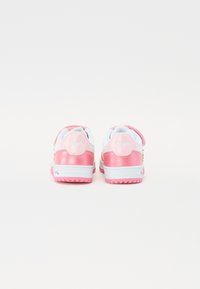 Rosa og hvite sneakers med glanset rosa aksent, teksturert hæl og borrelåsbelte. Baksiden har logo og flerfargede dekorative detaljer.