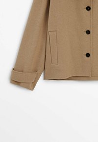 Brown wool-blend jacket with black buttons, featuring a fold-over collar, cuffed sleeves, and a side pocket detail. Soft texture.