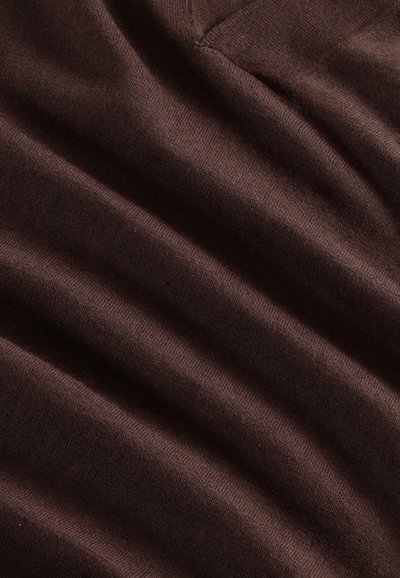 Tissu tricoté marron, présentant une texture lisse avec des nervures et des plis subtils, affichant une teinte riche et profonde. Aucun motif ni accent visible.