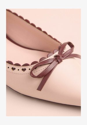 Light pink leather ballet flat with maroon bow detail and scalloped edging. Features heart-shaped cutouts along the upper.