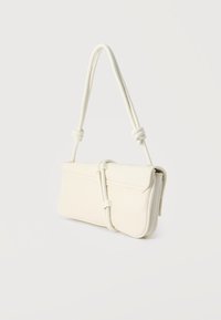 Τσαντάκι ορθογώνιο σε κρεμ χρώμα με πλεγμένο λουρί και κλείσιμο με καπάκι, μινιμαλιστικός σχεδιασμός σε απλό φωτεινό φόντο.