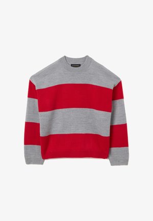 Jersey gris con rayas horizontales rojas, cuello redondo y puños acanalados. Textura de punto con un ajuste relajado. Etiqueta de la marca visible en el cuello.