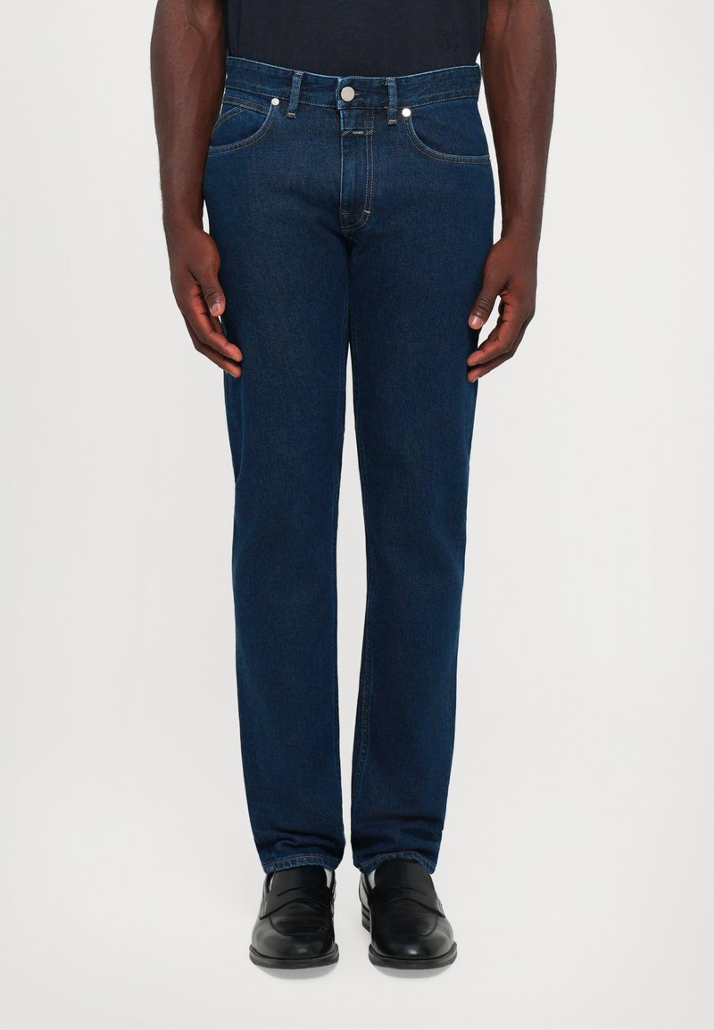 Dark blue denim jeans with a straight leg fit, five pockets, front button closure, and contrast stitching. Smooth texture, minimal detailing.