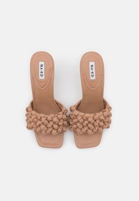 Nude slide sandals featuring woven textured strap and squared toe design. Made from soft material with contrasting stitching detail.