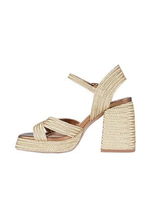 Sandalo platform beige intrecciato con tacco largo a blocco e cinturino alla caviglia, punta aperta e fibbie frontali incrociate.