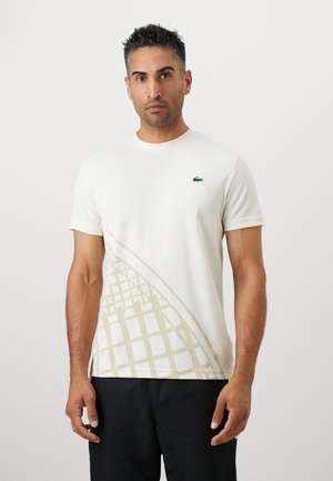 Short-sleeve cream t-shirt featuring a light beige geometric pattern and a small green logo on the chest, made from soft fabric.