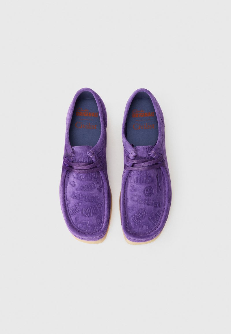 Chaussures en daim violettes avec des motifs gaufrés, bout arrondi et semelles en caoutchouc beige. Les semelles intérieures bleues arborent "Civlist" en lettres rouges.