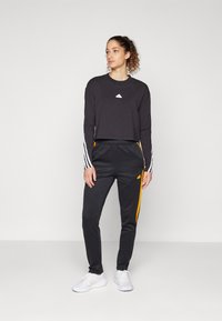 adidas Sportswear TIRO CUT 3 STRIPES TRACKPANTS - Treniņtērpa apakšdaļas - black/crew orange