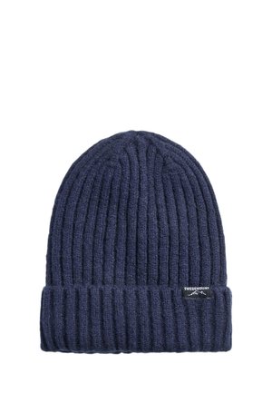 Bonnet en maille côtelée bleu foncé avec revers plié et petite étiquette noire affichant un logo montagne blanc et un texte.
