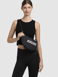 Crna, meka torba preko ramena zaobljenog oblika, s reljefnim bijelim natpisom "KHUJO 2001". Podesiva traka za svestranost.