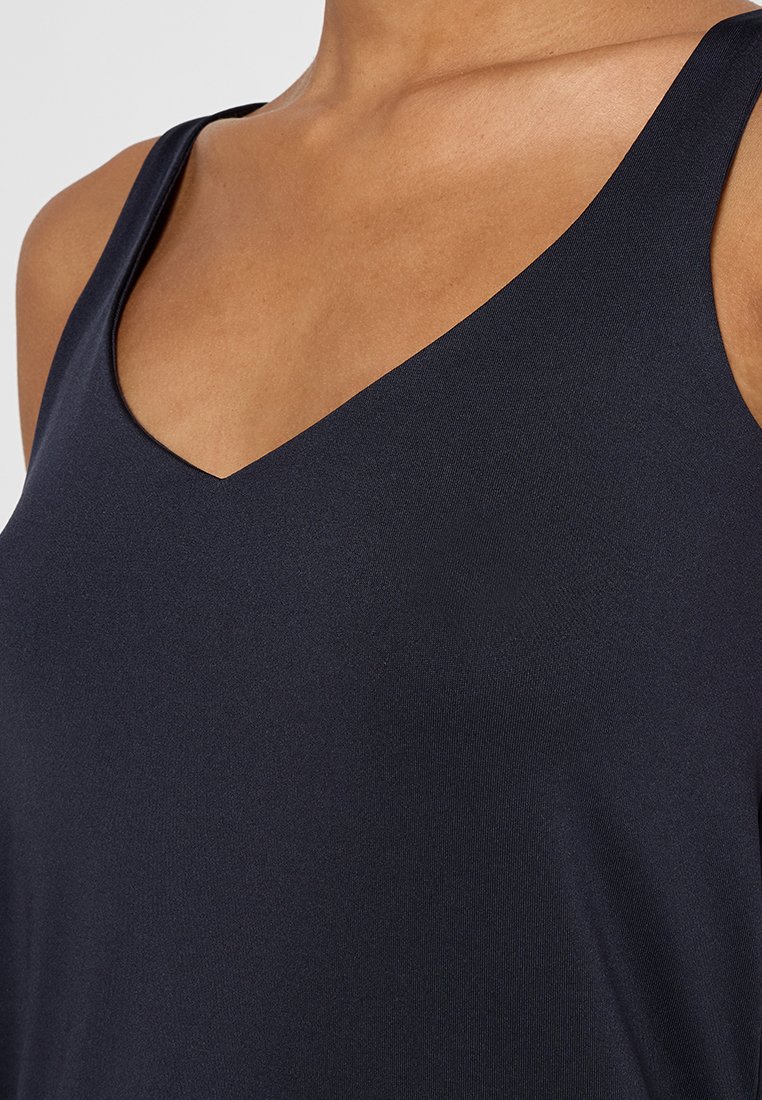 Débardeur sans manches bleu marine avec un décolleté en V, fabriqué en tissu lisse et extensible. Présente une coupe ajustée et un design minimaliste sans motifs.