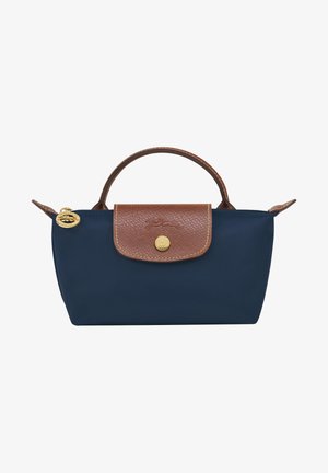 Navy blue nylon bag with a brown textured leather flap, gold hardware, and a short handle. Features a rounded shape and stitched accents.