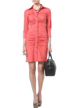 Koralfarvet skjortekjole med trekvartlange ærmer, med samlet tekstur ved taljen, to brystlommer, kombineret med en sort håndtaske.