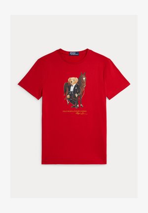 Crvena pamučna majica s grafikonom medvjeda u fraku uz konja, s natpisom "POLO BEAR by RALPH LAUREN" ispod u žutoj boji.