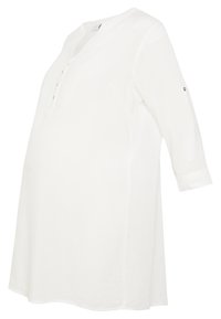 Bílá těhotenská tunika s polovičními rukávy, kulatým výstřihem, detailem knoflíků a volným střihem pro pohodlí během těhotenství.