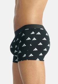 Czarne slipki z geometrycznym białym wzorem. Elastyczny pas, miękka tkanina, dopasowany krój z minimalną ilością szwów.