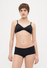 Svart soft-cup-bh med justerbare stropper og matchende svarte hipster-truser. Enkel design med jevn tekstur og minimal detaljering.