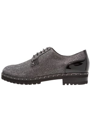 Chaussure Oxford texturée noire et grise avec talon noir brillant, lacets, semelle cloutée et motif de bande de roulement robuste.