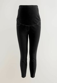 Leggings de maternité noirs avec une taille élastique, une longueur raccourcie et deux poches latérales ornées d'une couture contrastante.