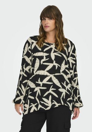 Haut noir à manches longues, avec un motif de feuilles blanches. Fabriqué en tissu léger avec une coupe décontractée et un col rond.