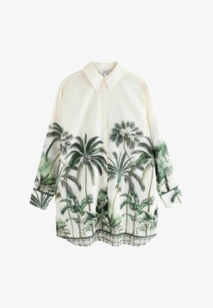 Šviesiai kreminės spalvos marškiniai su palmės medžių raštais ir dekoratyviniu gyvūnų raštu apatinėje dalyje. Ilgos rankovės su manžetais.