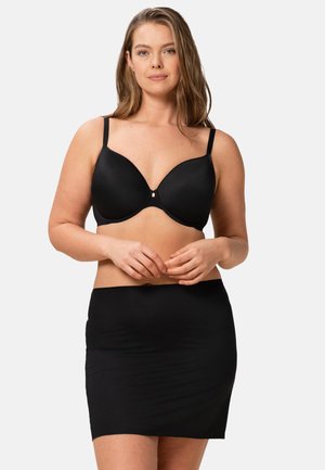 Soutien-gorge noir à bonnets lisses et bretelles réglables, assorti à une jupe noire ajustée. Les deux pièces présentent un design épuré et minimaliste.