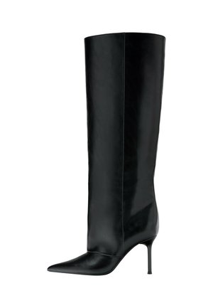 Une botte noire montant jusqu’au genou, à bout pointu, au talon haut et fin et à la finition en cuir lisse, sur fond blanc.