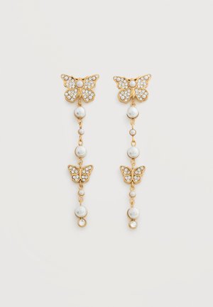 Gouden oorbellen met vlinderdruppel, versierd met heldere kristallen en witte parelmoer kralen langs een fijne ketting.