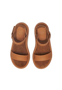 Tan leather sandals with two wide straps, adjustable ankle closure, and a soft suede insole. Smooth texture and flat sole design.