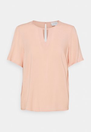 Lichtroze blouse met korte mouwen, ronde hals, vooraan een uitsparing in de vorm van een sleutelgat en een knoopsluiting aan de achterkant, weergegeven op een witte achtergrond.