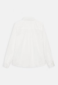 Hvid skjorte med lange ærmer, klassisk krave, knapmanchetter og en søm ved skulderstykket bagpå. Glat, vævet tekstur uden mønstre.