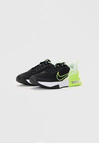 Black athletic shoes with mesh upper, neon green accents, white midsole, and textured rubber outsole, featuring a cushioned heel and laces.