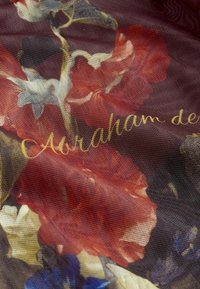 Tissu sombre et transparent avec un motif floral comprenant des fleurs rouges, blanches, bleues et le texte en script doré "Abraham de" partiellement visible.