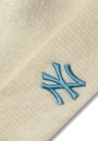 Beanie lavorato a maglia color crema con una consistenza morbida, caratterizzato da un logo ricamato blu "NY" sul davanti. Dettagliato con un design aderente.