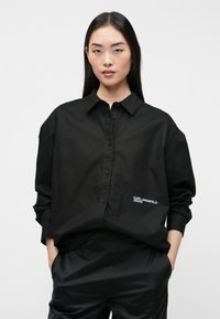 Camisa negra de botones, confeccionada en una tela suave, con un cuello clásico, un corte relajado y el detalle bordado "KARL LAGERFELD JEANS".