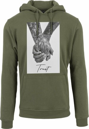 Olivgrüner Kapuzenpullover mit einem Frontgrafik, die zwei tätowierte Hände zeigt, die eine Blume halten. Text "Vertraue" in einer geschwungenen Schriftart am unteren Rand.