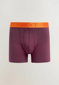 Burgundy boxer alsónadrág narancssárga rugalmas derékkal, amelyen a "NEXT" logó található. Sima textúra, közepes hosszúság, és testhezálló kivitel.