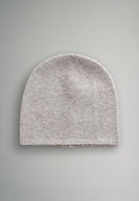 Jasnoszara dzianinowa czapka z lekko zaokrąglonym wierzchołkiem, teksturowanym materiałem i podwiniętym brzegiem. Materiał wydaje się miękki z subtelnymi drobinkami.