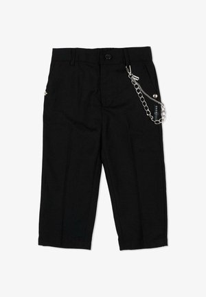 Zwarte cropped broek met knoopsluiting en decoratieve zilveren ketting met een klein label aan de voorste tailleband bevestigd.