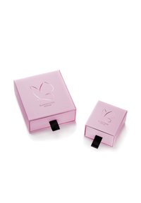 Du šviesiai rožiniai dėžutės su blizgiu paviršiumi. Didesnė dėžutė yra kvadrato formos su drugelio logotipu; abi turi juodus raiščius, skirtus atidaryti.