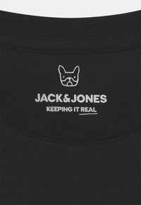 T-shirt in cotone nero con scollo rotondo. Presenta il testo stampato in bianco "JACK & JONES KEEPING IT REAL" e un logo di cane sul retro.