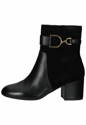 Stivale alla caviglia nero con upper in suede e dettagli in pelle. Presenta una fibbia dorata e un tacco spesso. Texture liscia, punta appuntita.
