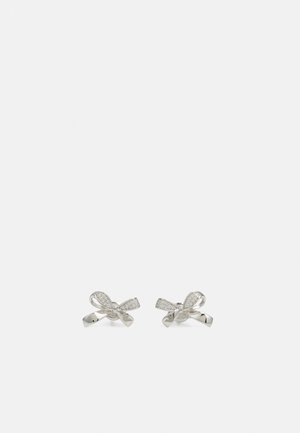 Silver bow-shaped stud earrings with small embedded crystals on a plain light gray background.
