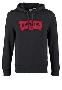 Sweat à capuche noir avec poche avant et cordons, arborant un grand logo Levi's rouge sur la poitrine.