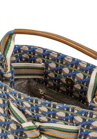 Wielokolorowa tkana torba z geometrycznym wzorem, posiadająca drewnianą rączkę oraz materiałowe paski dekoracyjne w kolorach niebieskim, zielonym i pomarańczowym.