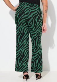 Gröna och svarta tigerstrimmiga vida byxor med en texturerad tyg, med hög midja och diskreta sidofickor.