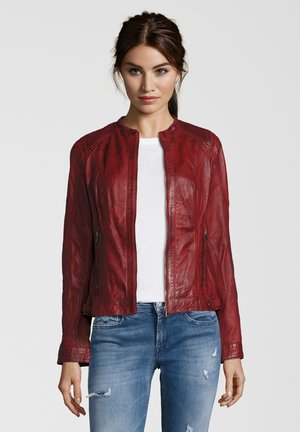 Rote Lederjacke mit rundem Ausschnitt, Reißverschluss und gerippten Akzenten. Tragen über einem weißen Oberteil und kombiniert mit ausgewaschenen blauen Jeans.