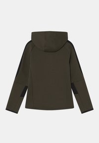 Hættejakke i olivengrøn med sorte sideaccenter, der har en glat tekstur og tætsiddende design. Bagside viser hætten og sømmene.