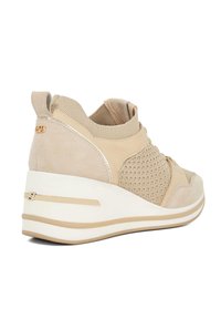 Beige wedge sneakers met gemengde materialen van suède en mesh, een slank ontwerp, een dikke witte zool en gouden accenten op de hiel en zijkant.