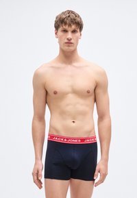 Μποξεράκια από βαμβάκι σε ναυτικό μπλε χρώμα με κόκκινη ελαστική μέση που έχει το λογότυπο "JACK & JONES", εφαρμοστή σχεδίαση και μεσαίου μήκους πόδια.